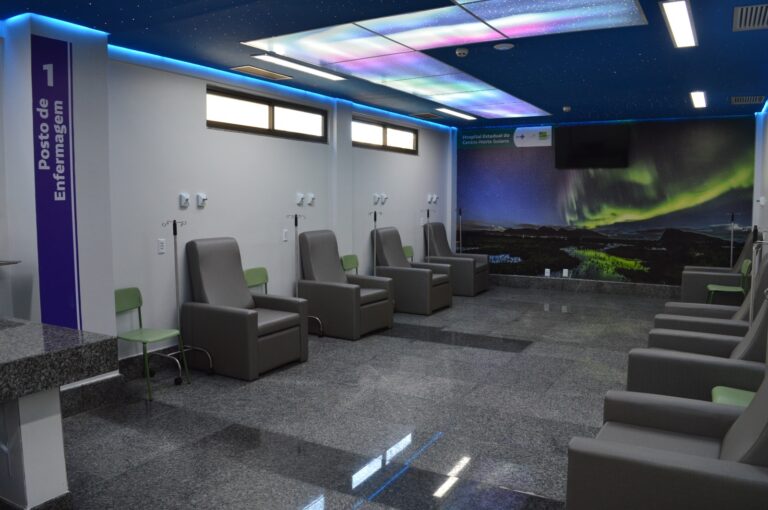 Foto do centro oncologia do HCN, com poltronas, painel decorado no teto e parede com foto da aurora boreal