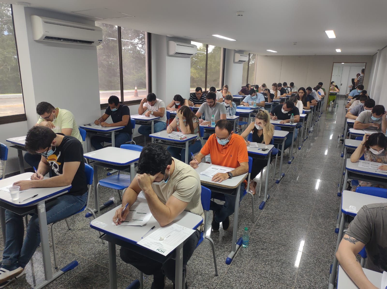 Sala com diversas cadeiras ocupadas por inscritos realizando prova de residência médica no HCN