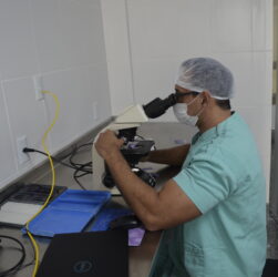 Médico patologista do hospital realizando o procedimento de biópsia por congelação no microscópio