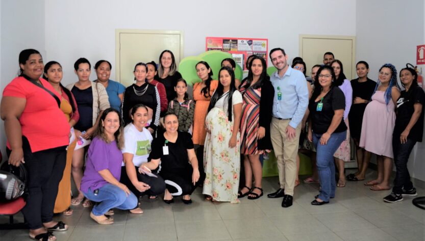 Esta imagem contém, dois homens e várias mulheres posando para a foto lado a lado e algumas abaixadas. Entre essas pessoas estão mulheres gestantes no HCN, violência obstétrica, parto humanizado