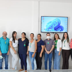 Na imagem em destaque encontrasse nove mulheres e dois homens, todas as pessoas estão posando para uma foto em fileira, à frente de uma parede branca. O treinamento foi realizado para capacitar equipe sobre doação de órgãos e transplantes.