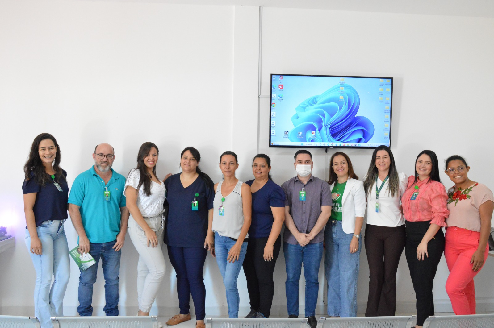 Na imagem em destaque encontrasse nove mulheres e dois homens, todas as pessoas estão posando para uma foto em fileira, à frente de uma parede branca. O treinamento foi realizado para capacitar equipe sobre doação de órgãos e transplantes.