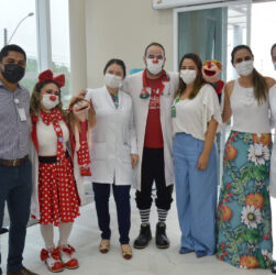 Equipe e colaboradores do Hetrin posam para uma foto lado a lado, com o grupo voluntário Missão Sorrisos que são palhaços com fantoches.