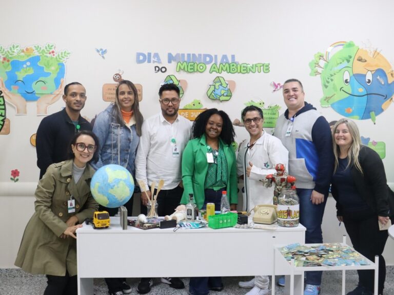 Imagem de colaboradores do Hospital Municipal da Brasilândia (HMB) participando do projeto "Salvei uma Orquídea", onde recebem mudas e aprendem sobre práticas sustentáveis.