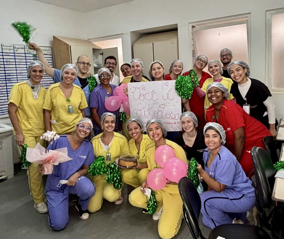 Profissionais do HEF aplaudem paciente em corredor de homenagem após sete meses de internação e recuperação.