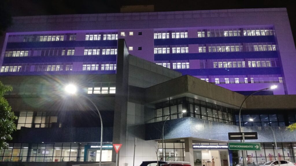 Fachada do Hospital Municipal da Brasilândia iluminada em roxo durante a campanha Janeiro Roxo de conscientização sobre a hanseníase.